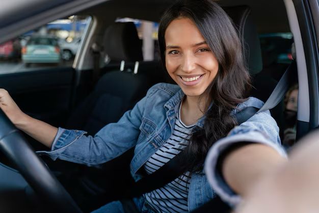 Mujer tomándose selfie en coche. Foto: Freepik