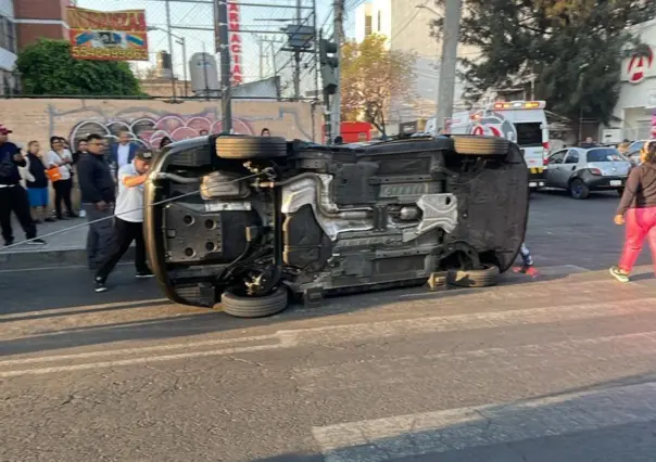 Auto termina volcado tras chocar contra unidad de transporte en Iztacalco