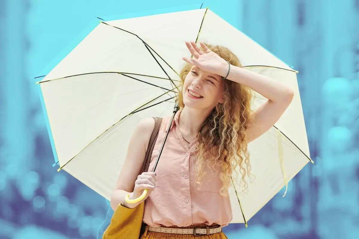 Mujer con sombrilla y calor. Foto: Canva