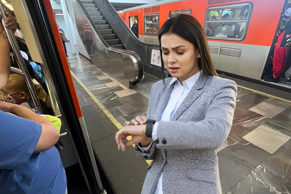 Persona dentro de los vagones del Metro de CDMX que están detenidos en la estación y una mujer viendo su reloj al frente. Foto: X (@Roy79297870)