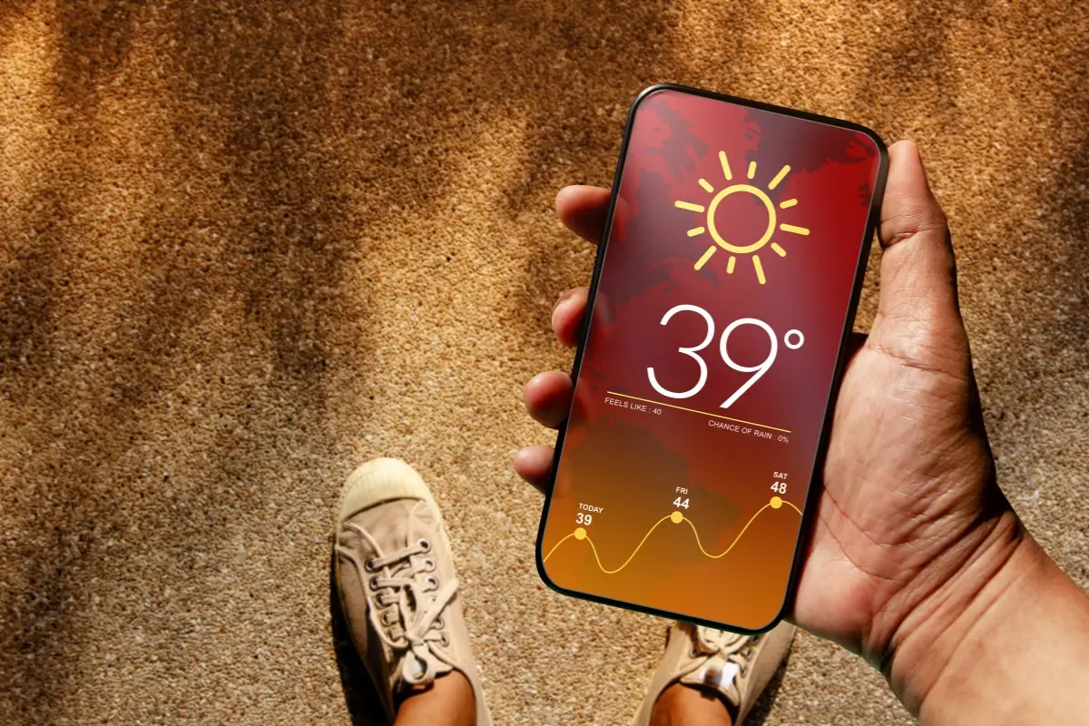 Persona con un celular y el pronóstico del tiempo. Foto: Canva