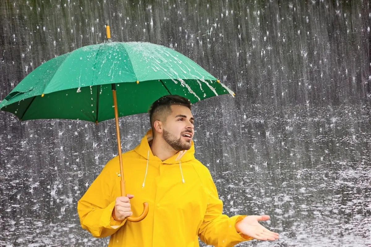 Un hombre con paraguas y lluvia. Foto: Canva