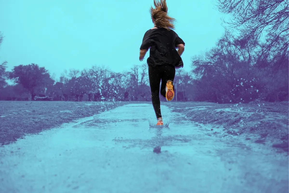 Mujer corriendo en la lluvia. Foto: Canva