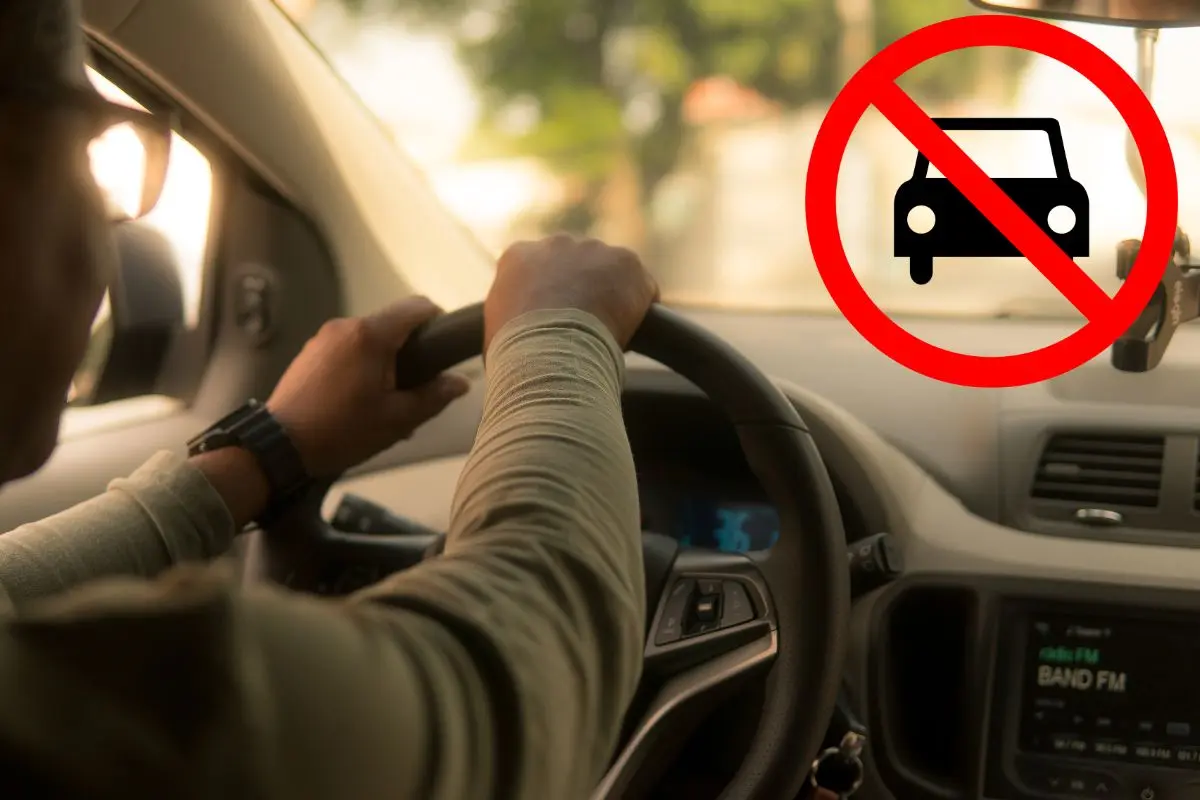 Persona manejando su auto, logo de prohibido autos.      Foto: Canva
