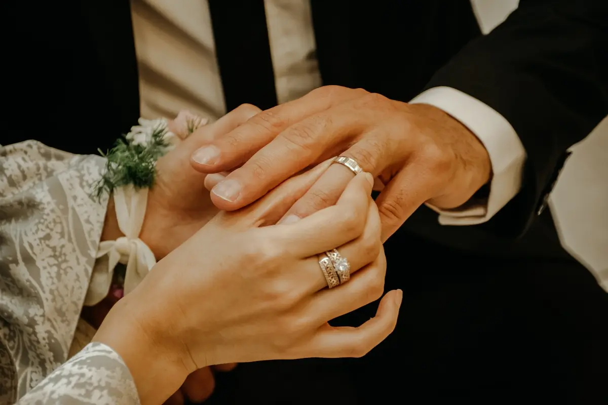 Pareja colocándose anillos. Foto: Canva