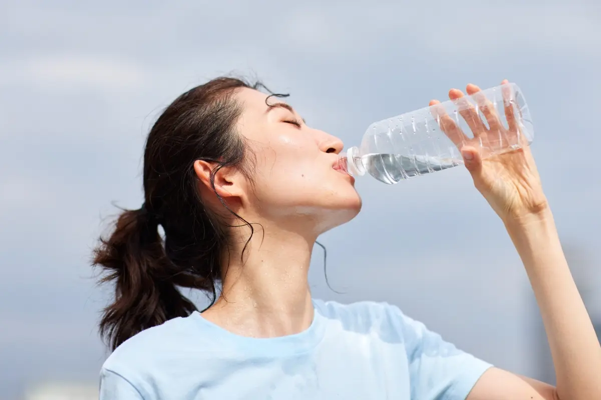 Mujer tomando agua. Foto: Canva