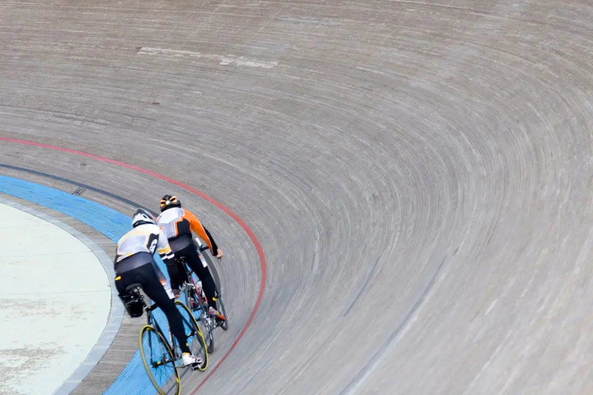 Ciclistas en un velódromo. Foto: Canva