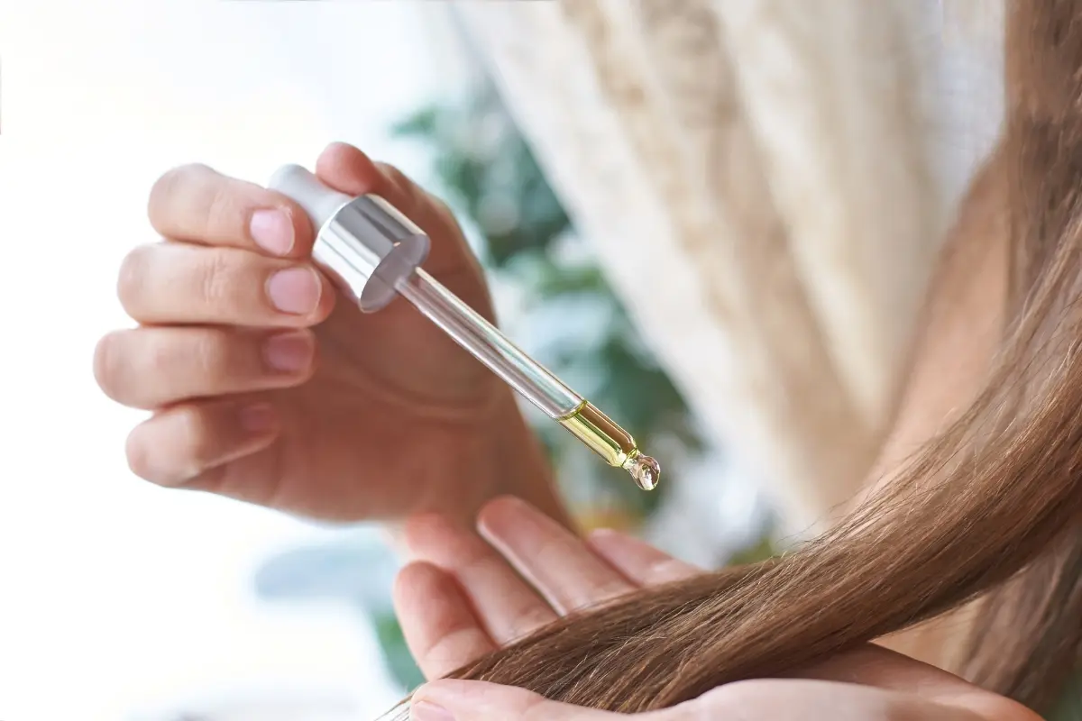 Una mujer aplicándose tratamiento en cabello. Foto: Canva