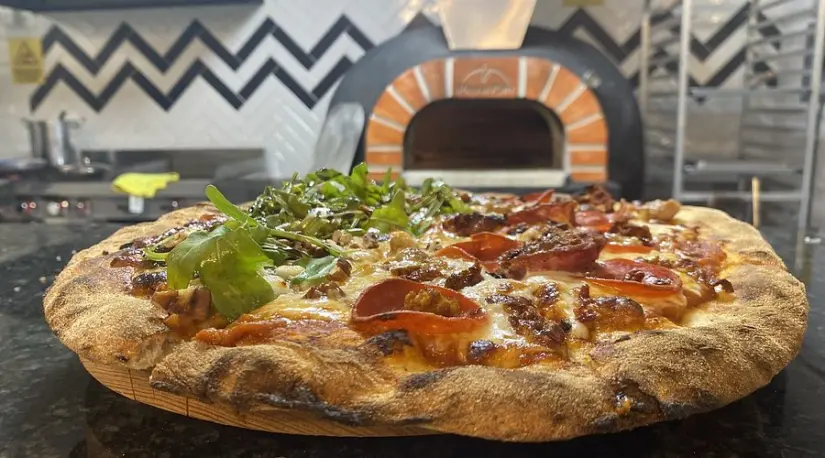 Horno de leña de Don Vitto Piza, y una pizza artesanal recién salida, con masa madre y toppings de calidad. Foto: TripAdvisor.