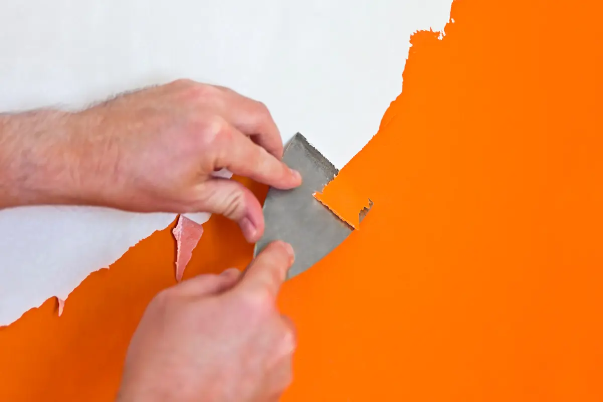 Antes de pintar la pared, se debe asegurar el retiro de la pintura vieja y la reparación de grietas. Foto: Canva