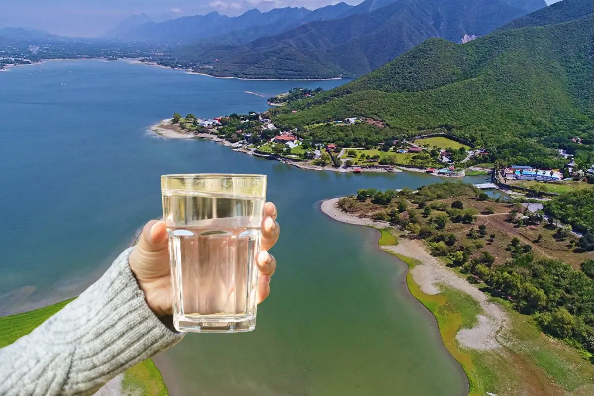 La Presa La Boca de fondo con una mano que sostiene un vaso de agua Foto: Canva