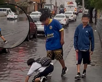 Niños cruzan calle inundada sin supervisión en medio de fuertes lluvias en Saltillo
