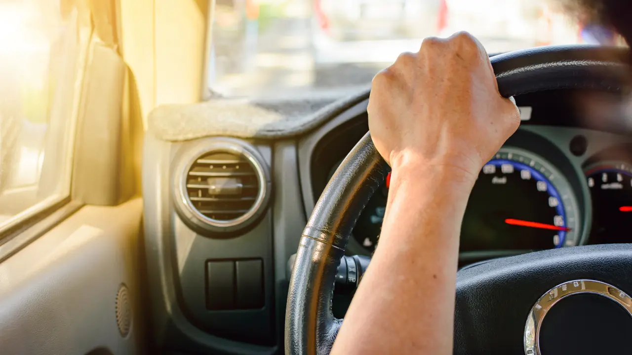 Persona al volante en medio del tráfico. Foto: Canva