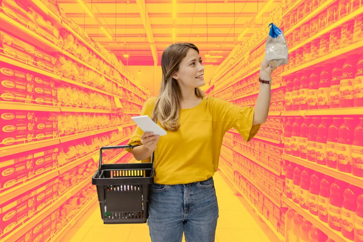 Un pasillo de supermercado y una mujer comprando. Foto: Canva