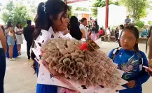 Padre migrante envía ramo de billetes a su hija por su graduación en Puebla
