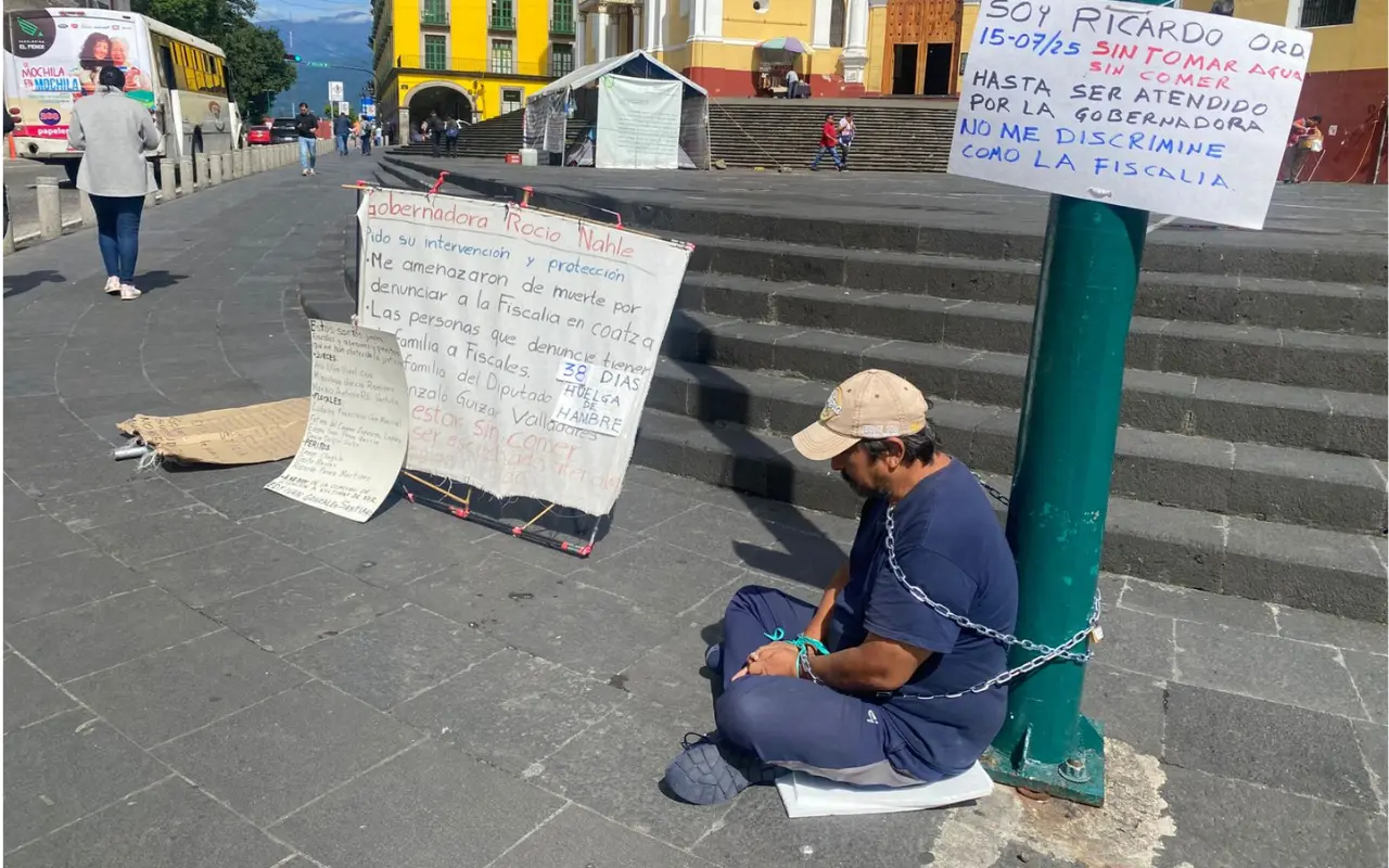 Hombre encadenado en protesta. Foto: Rosalinda Morales