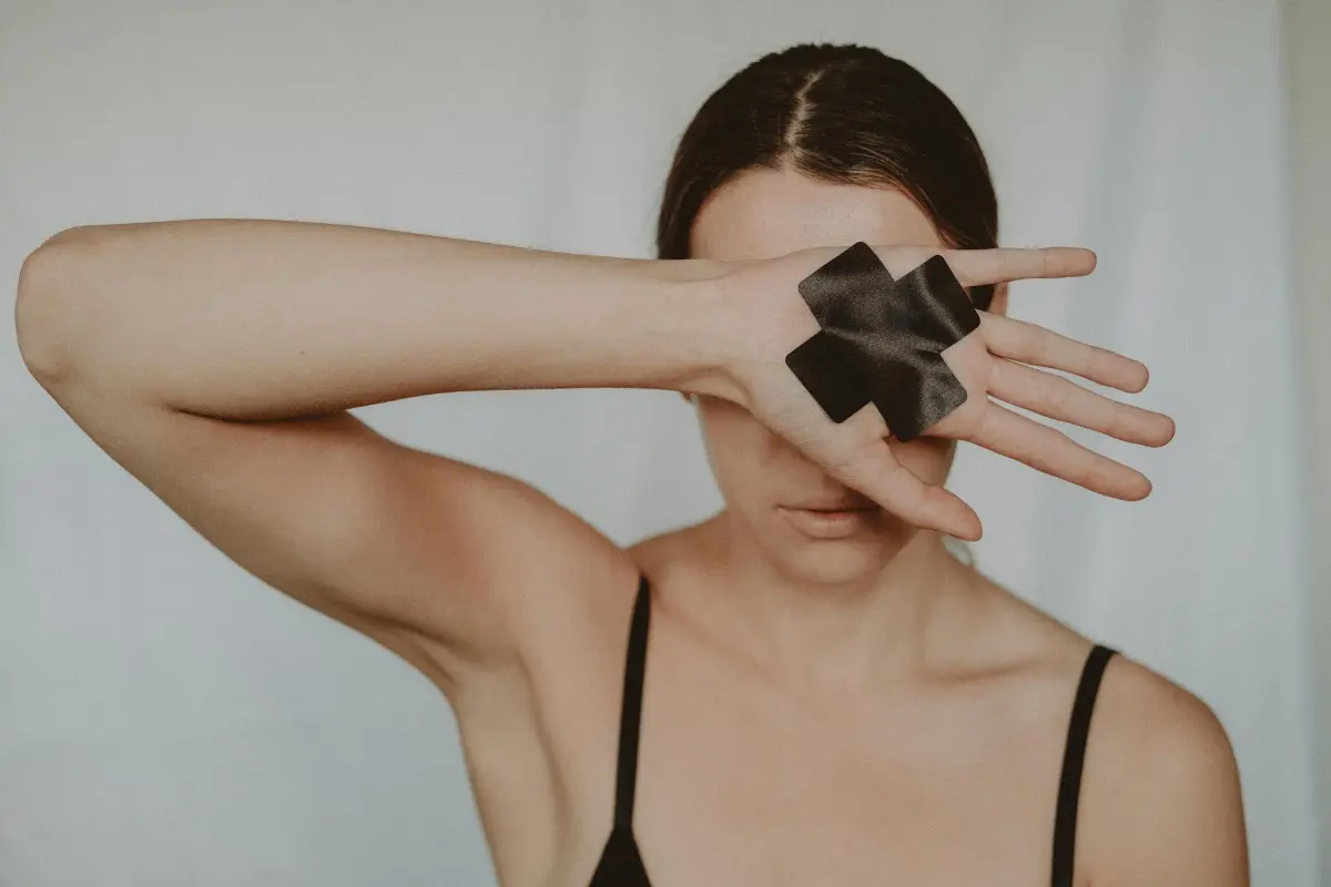 Una mujer tapando su rostro. Foto: Canva
