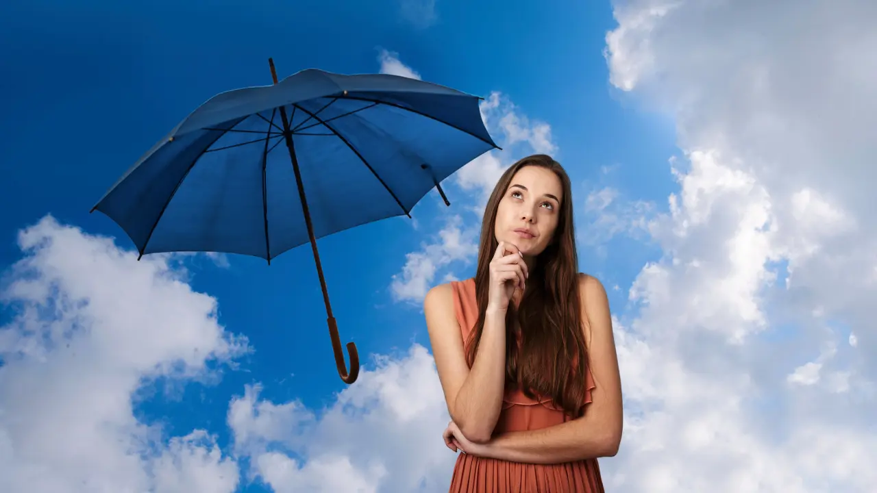 Cielo medio nublado, con una mujer y un paraguas. Foto: Canva