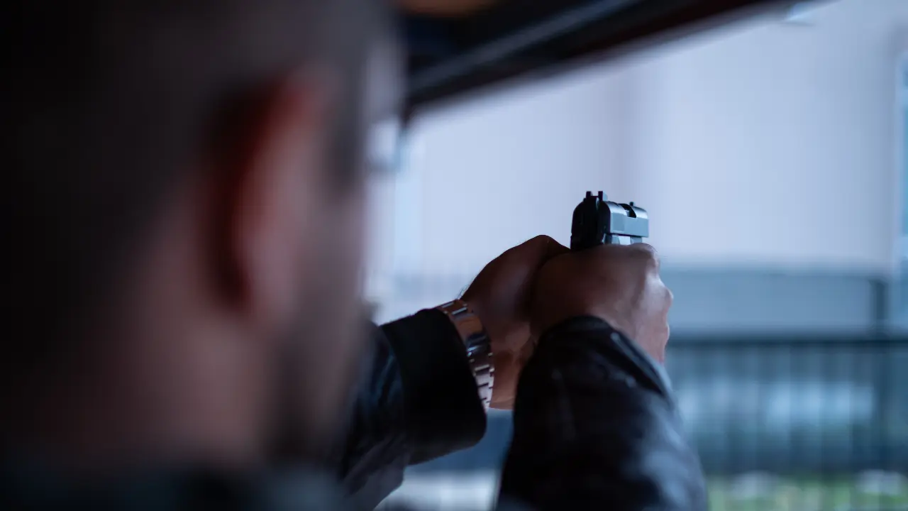 Sujeto apuntando con un arma. Foto: Canva