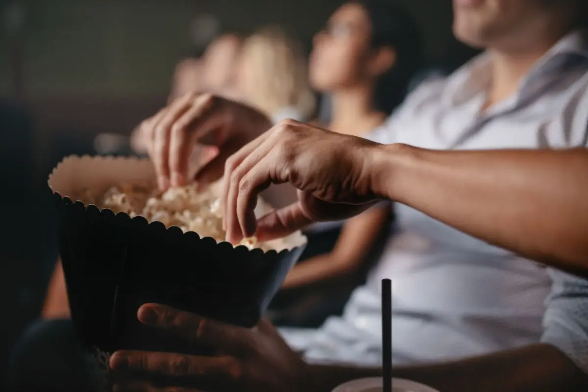 Palomitas y personas en una sala de cine Foto: Canva