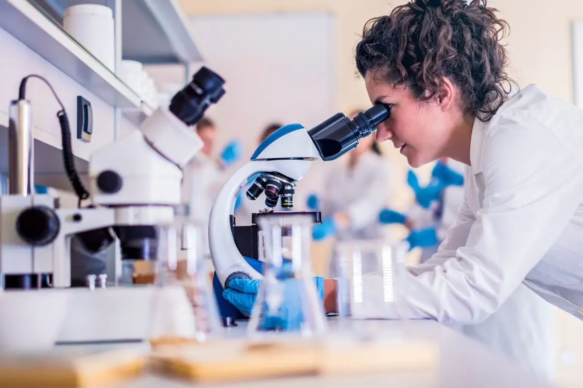 Científica con un microscopio Foto: Canva
