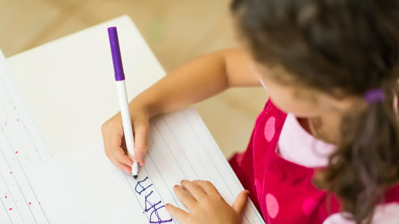 Niña aprendiendo a escribir. Foto: Canva