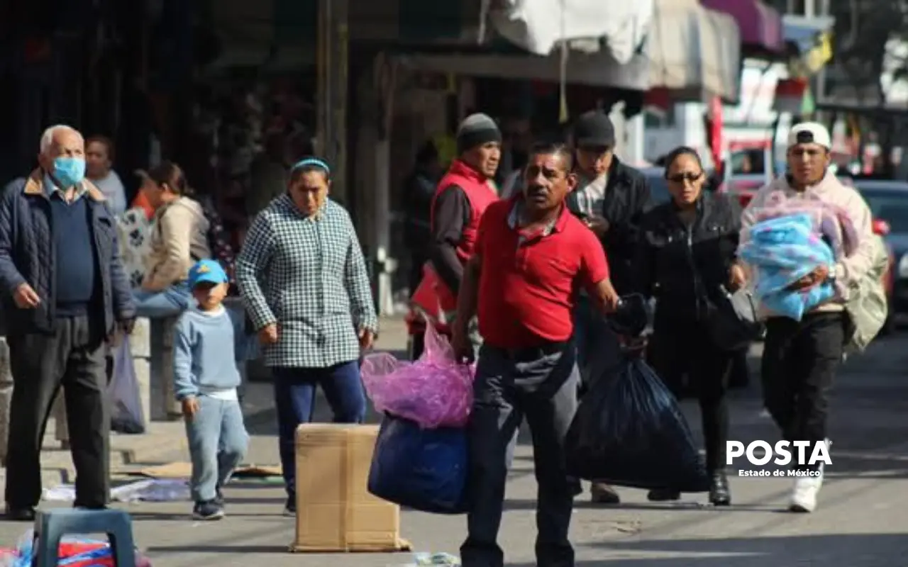 Hombre comerciante cargando bolsas en la ciudad. Foto: Alberto Dzib