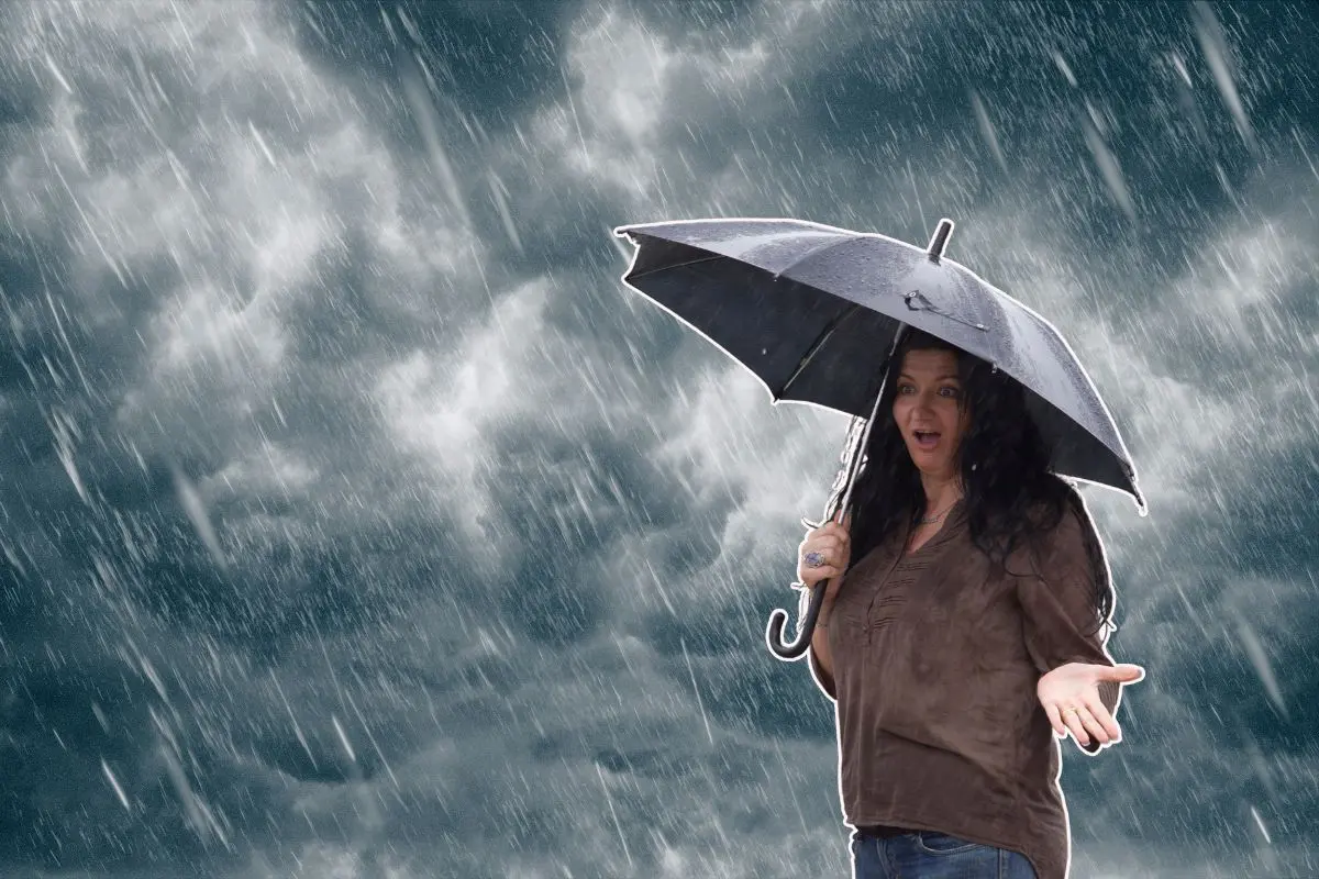 Mujer con paraguas cubriéndose de la lluvia Foto: Canva