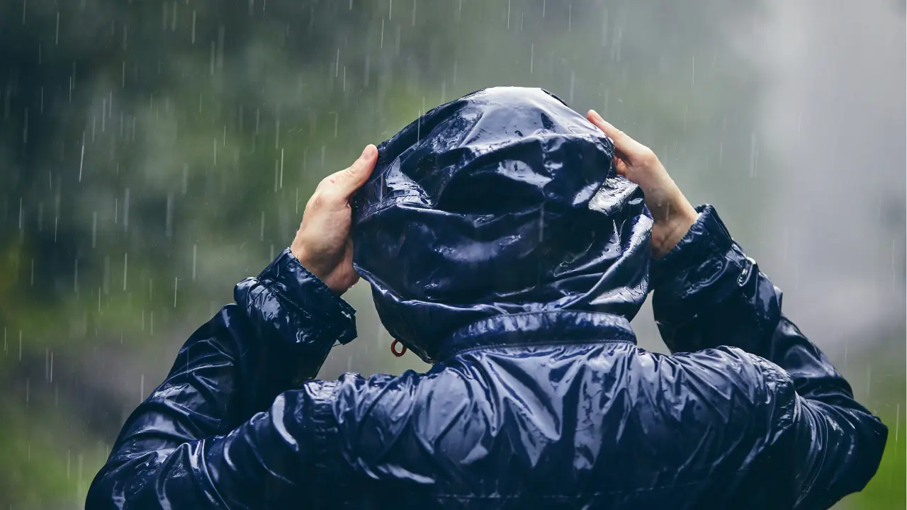 Hombre con un impermeable azul. Foto: Canva