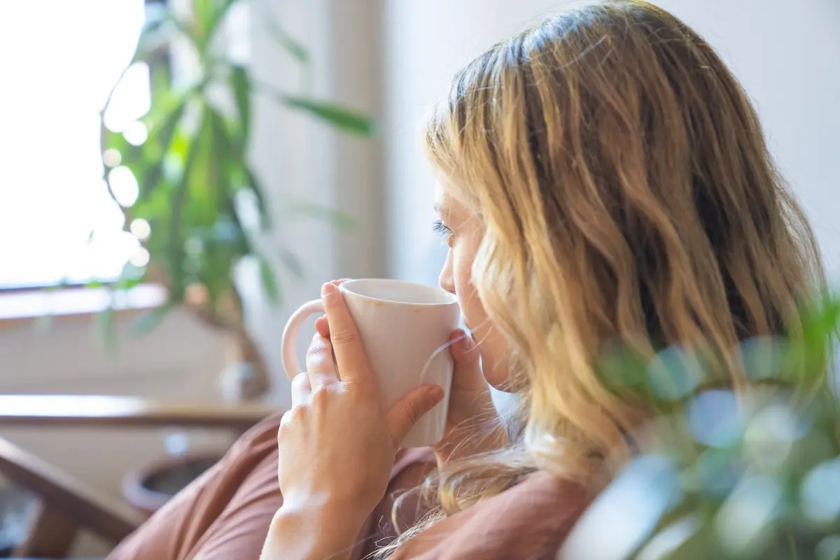 Una persona tomando desde una taza. Foto: Canva