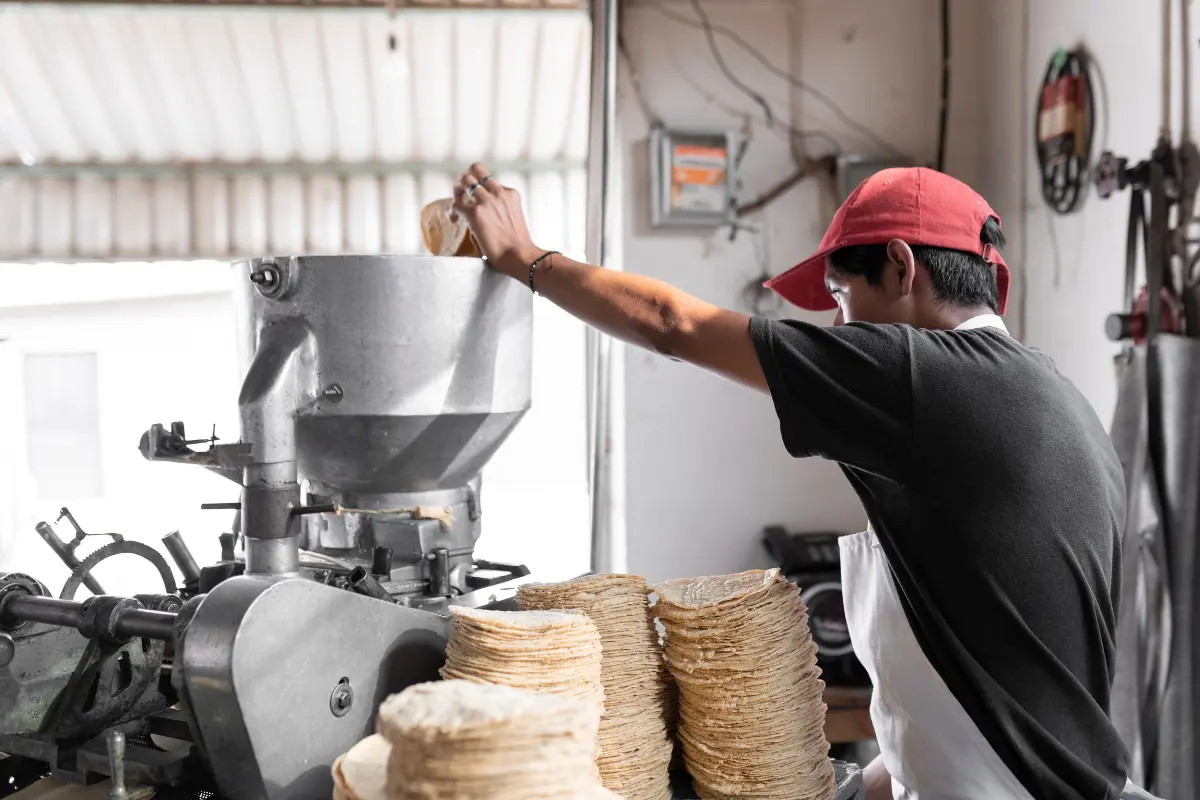 Persona trabajando en tortillería. Foto: Canva