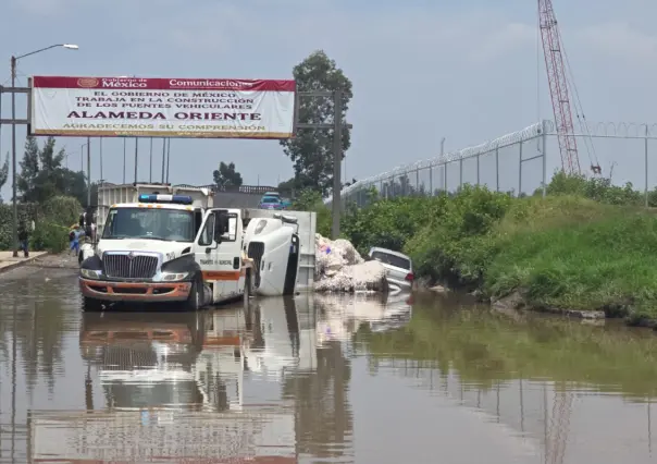 FOTOS | Tráiler se vuelca en Periférico Oriente por baches e inundación