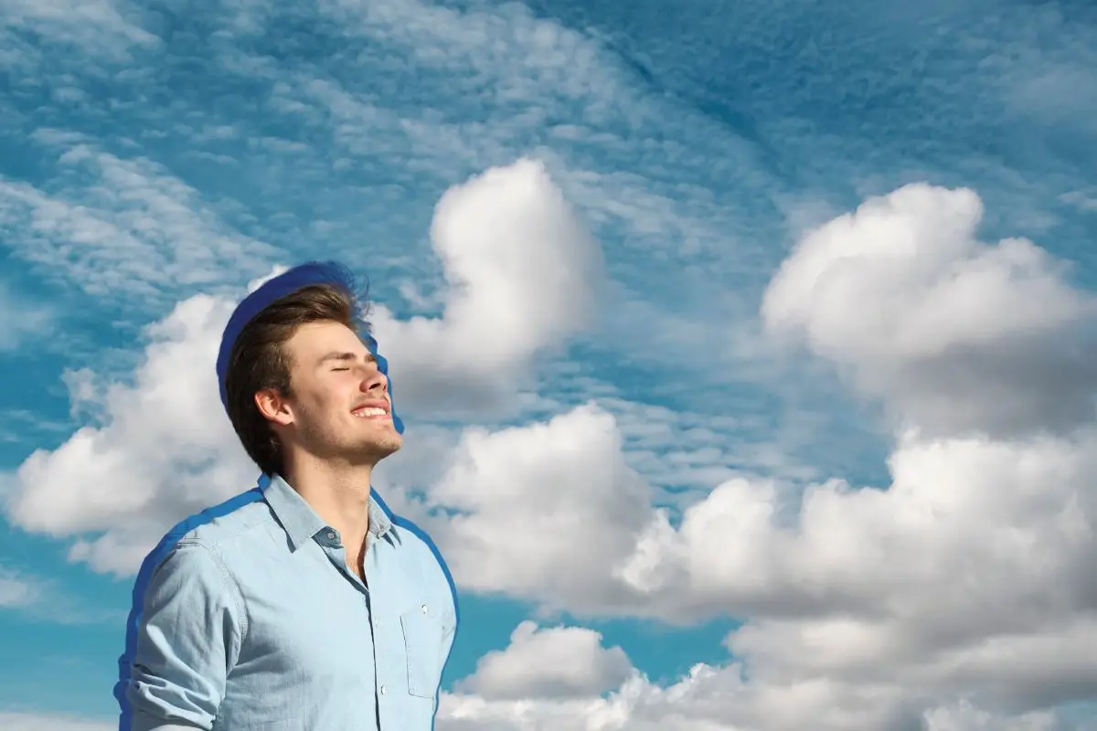 Hombre sonriendo y un cielo de fondo Foto: Canva