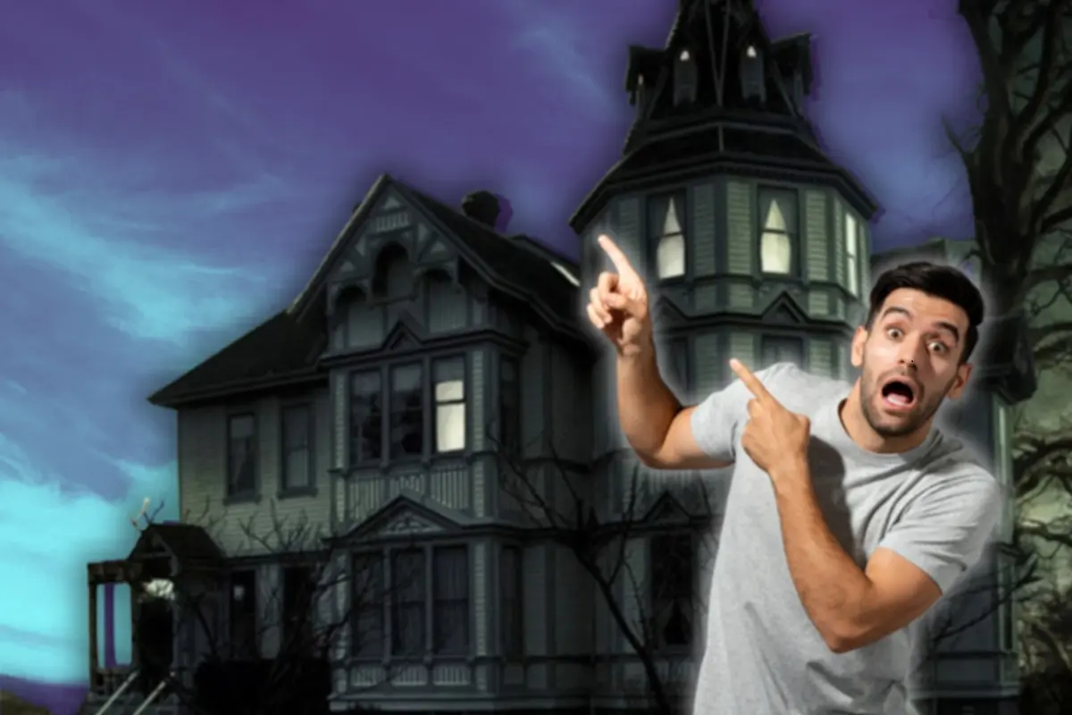 Hombre apuntando a una casa del terror sorprendido Foto: Canva