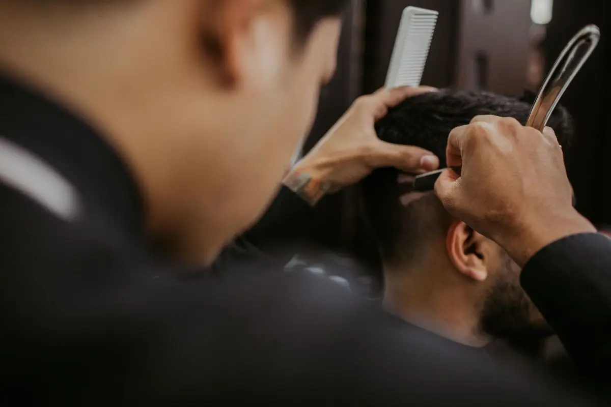 Hombre cortando el cabello con navaja Foto: Canva