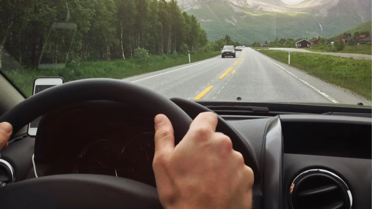 Persona manejando en carretera. Foto: Canva