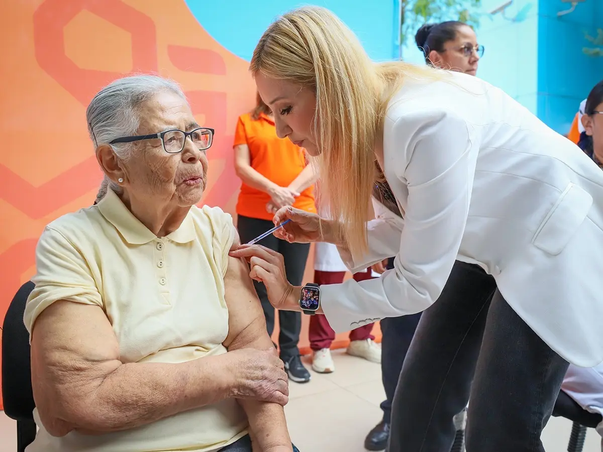 La secretaria de Salud de Nuevo León, Alma Rosa Marroquín, aplica una vacuna a una mujer de la tercera edad durante el arranque de la campaña de vacunación por temporada invernal donde se aplicarán las vacunas contra la Influenza, COVID-19 y Neumococo. Foto: Gobierno de Nuevo León