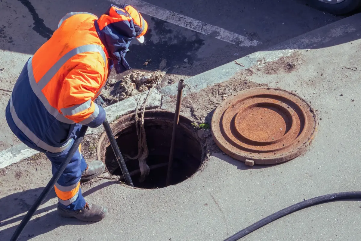 Una persona trabajando en una alcantarilla. Foto: Canva