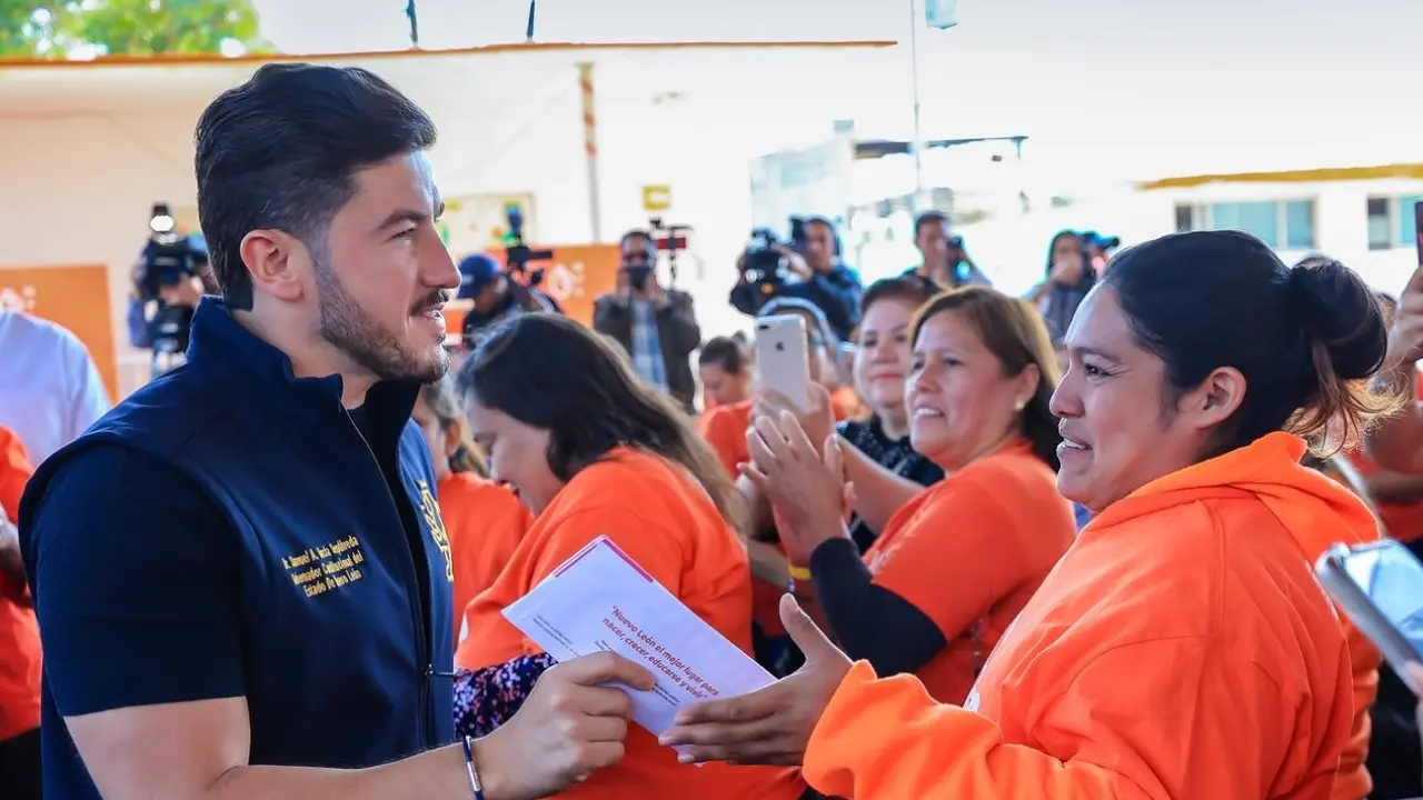 El gobernador de Nuevo León, Samuel García y una mujer recibiendo su tarjeta. Foto: