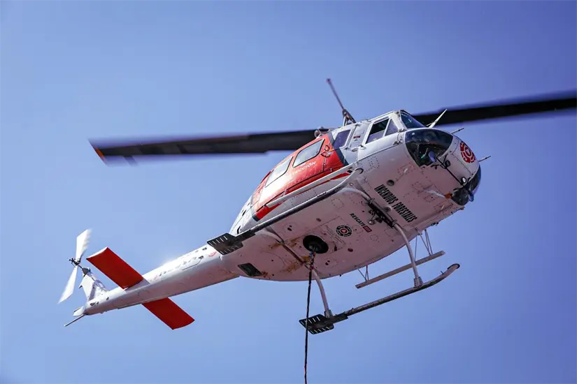 Helicóptero de Protección Civil de Nuevo León sobrevuela el cerro para descargar agua Foto: PCNL
