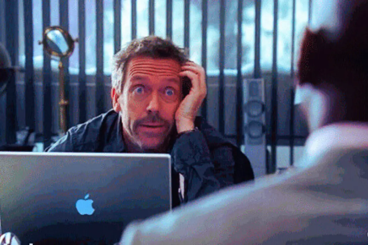 Hugh Laurie caracterizando al doctor House frente a una MacBook (Foto: YouTube, Dr. House: Diagnóstico Médico / Canva)