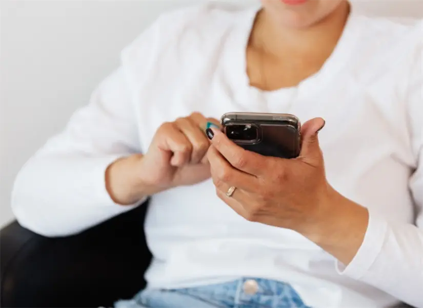 imagen recuadro Joven viendo contenido en redes sociales mediante su celular. Foto: Canva.