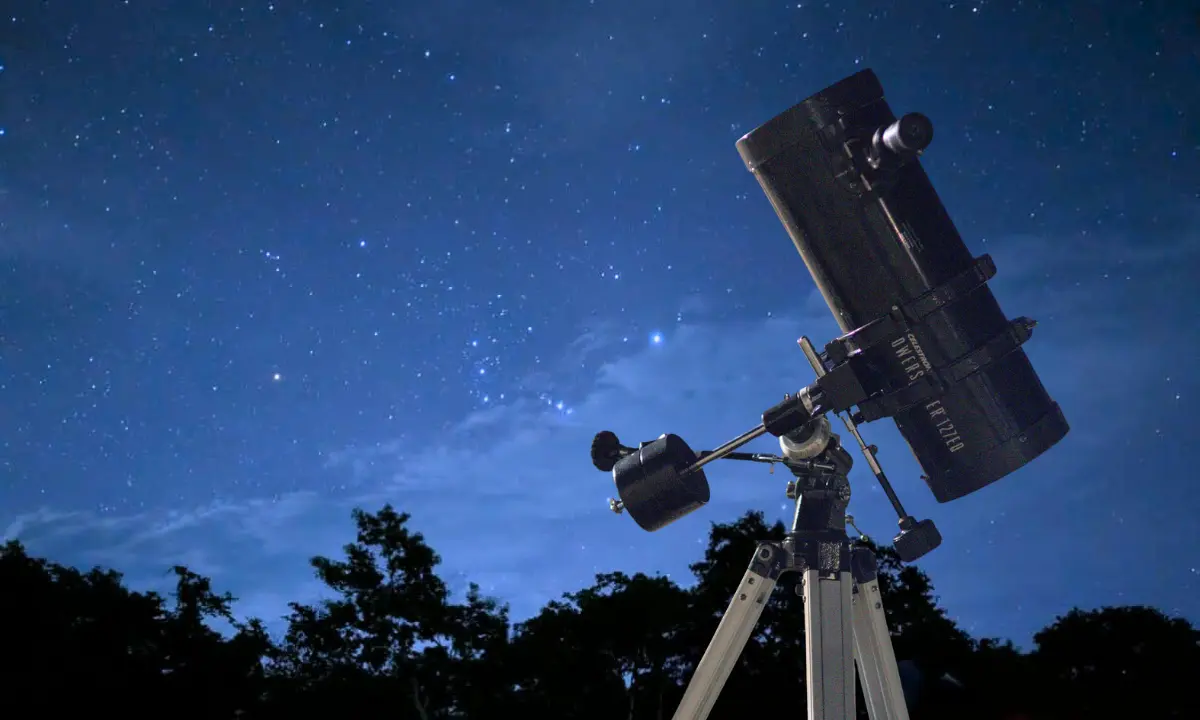 Cielo nocturno en Yucatán y en primer plano un telescopio Foto: Sociedad Astronómica UADY/Canva