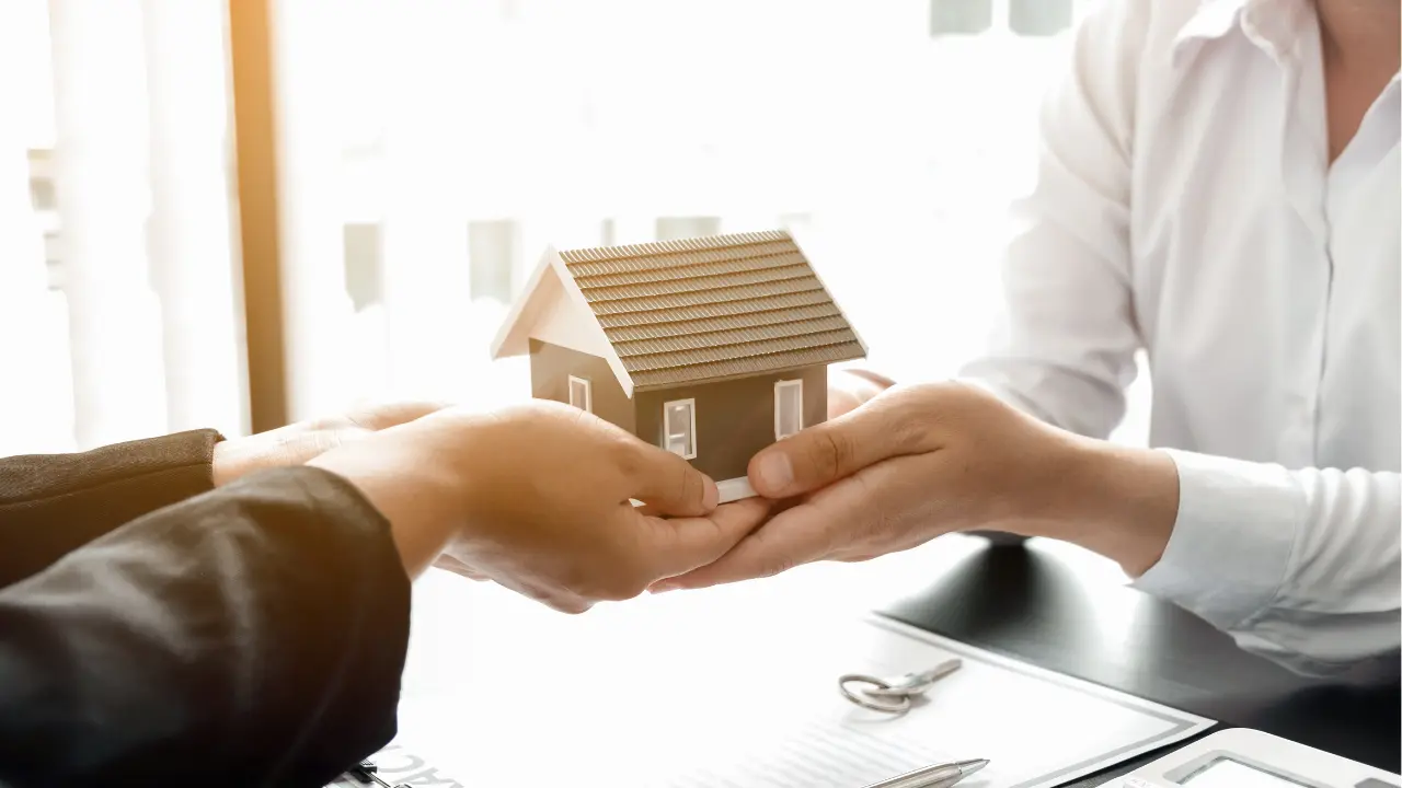 Dos personas realizando un contrato para asegurar una vivienda | Canva Pro