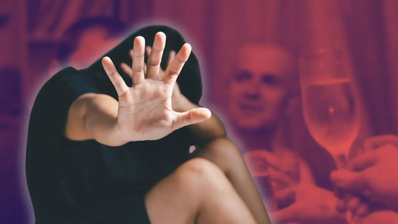 Una mujer y de fondo personas con copas de vino. Foto: Canva