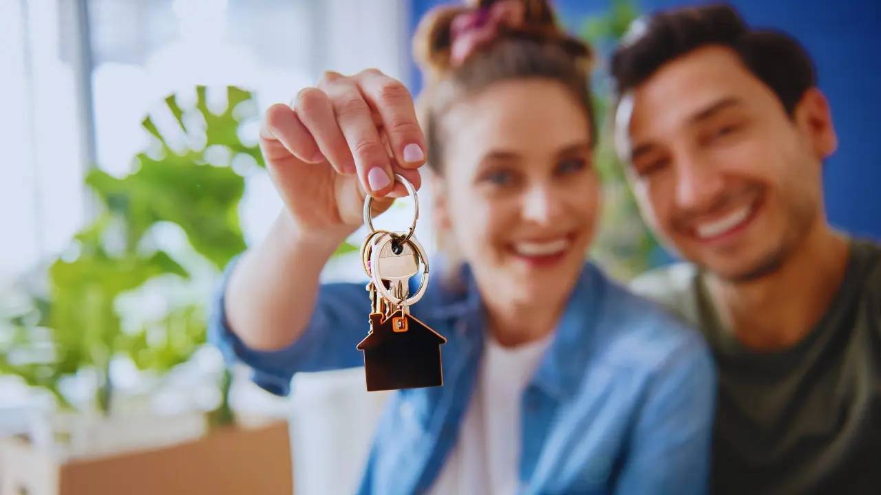 Llaves de una casa y una pareja. Foto: Canva