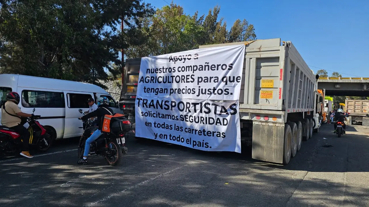 Bloqueo en la México–Texcoco por transportistas y pancarta de sus exigencias. | Foto: Luis Antonio Alfaro