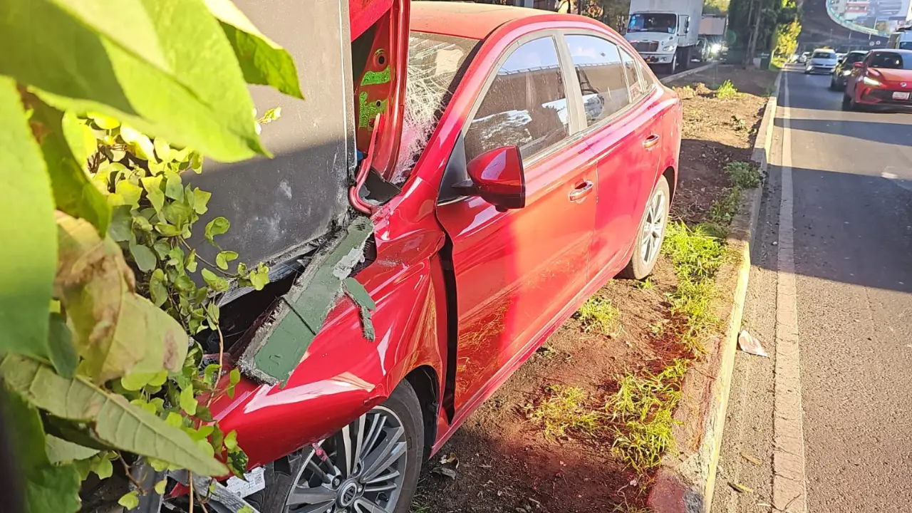 Accidente de auto en periférico. Automóvil rojo sobre camellón. Foto: Ramón Ramírez