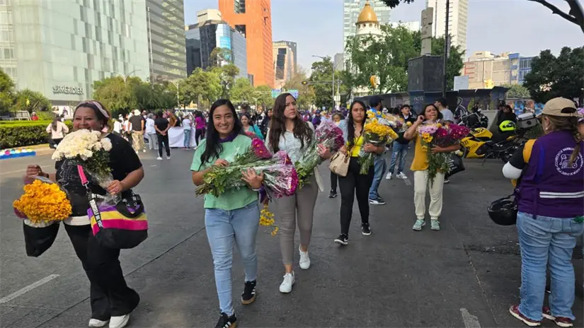 Colectivos dando flores en la marcha del 25N en CDMX. Foto: Mario Flores