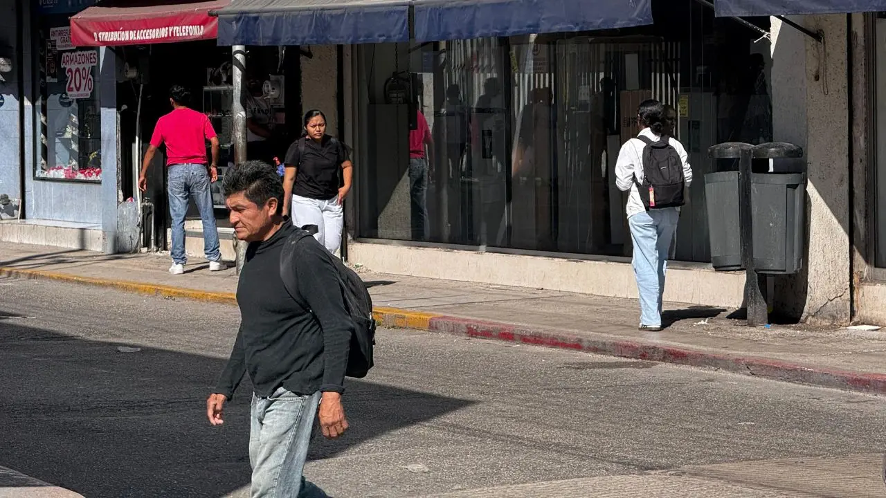 Personas caminan por una calle de Mérida usando suéter ante las bajas temperaturas que se registran en la región.- Fuente Irving Gil